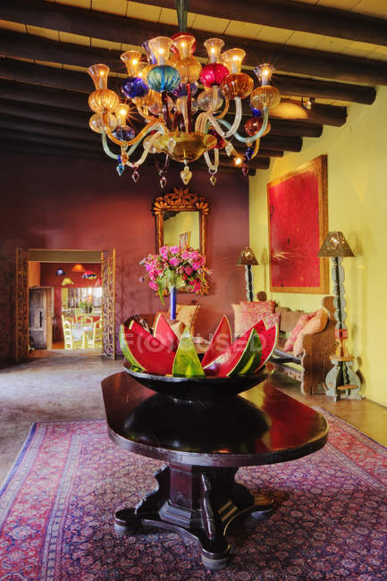 Обеденная зона с арбузным декором на столе и винтажной люстрой — стоковое фото