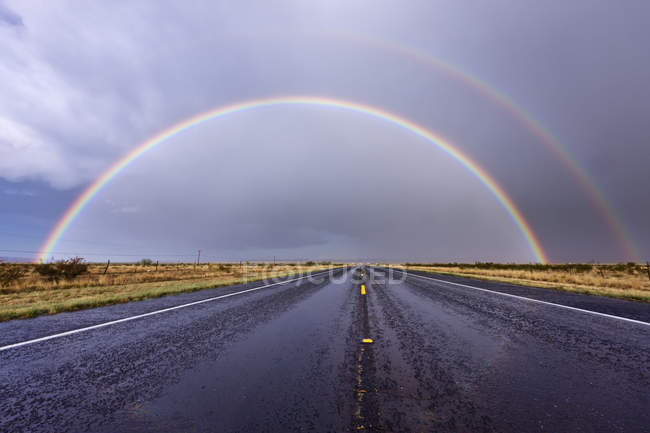 Rainbow on rural road in countryside of Texas, USA — Stock Photo