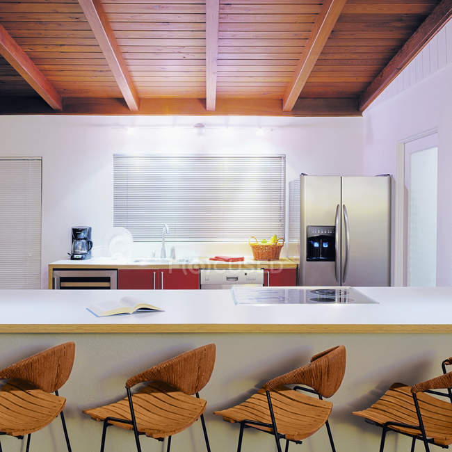 Cozinha com fileira de cadeiras por balcão, design de interiores moderno — Fotografia de Stock