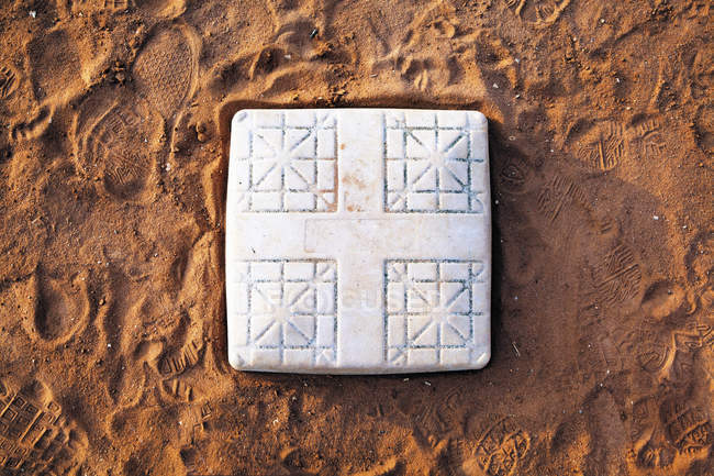 Base sul campo da baseball con impronte, primo piano — Foto stock