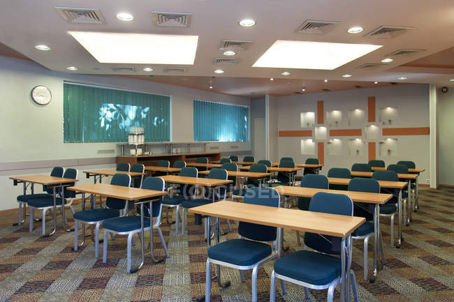 Mesas e cadeiras na moderna sala de conferências vazia — Fotografia de Stock