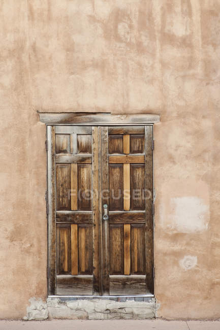 Alte hölzerne Tür in verwitterter Lehmhausfassade, Santa Fe, New Mexico, Vereinigte Staaten — Stockfoto