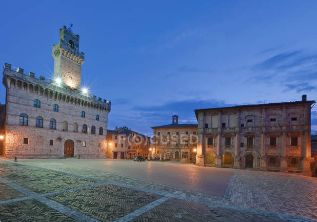 Palazzo Comunale sur la place illuminée au crépuscule, Montepulciano, Toscane, Italie — Photo de stock