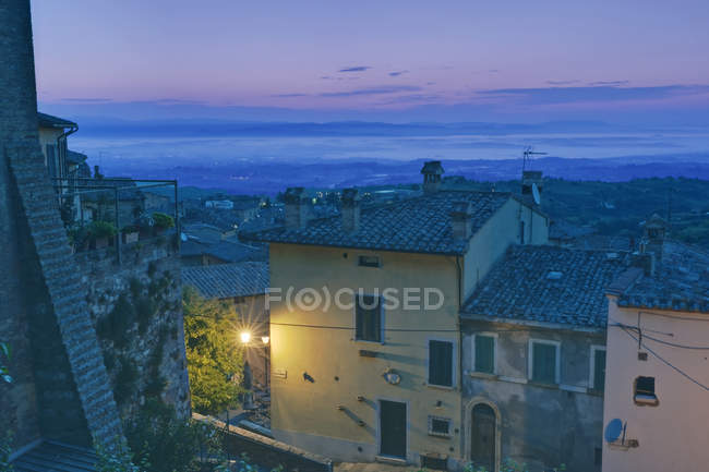 Montecchiello paese strada illuminata con edifici all'alba, Toscana, Italia — Foto stock