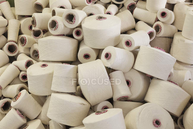 Flax spools in bulk in manufacturing factory, full frame — Stock Photo