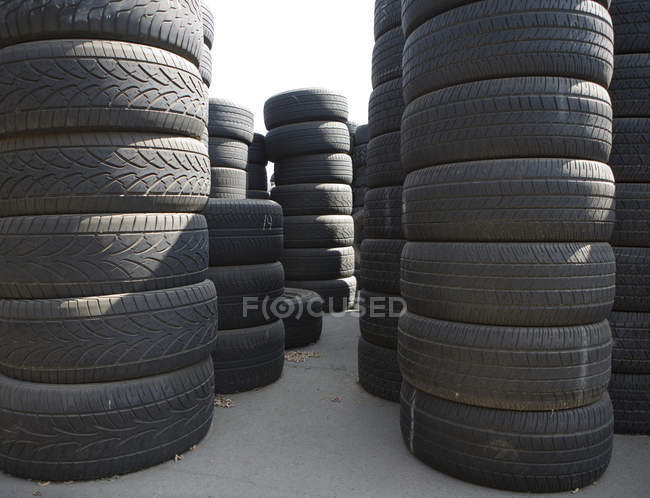 Piles de pneus automobiles usagés empilées à l'extérieur — Photo de stock
