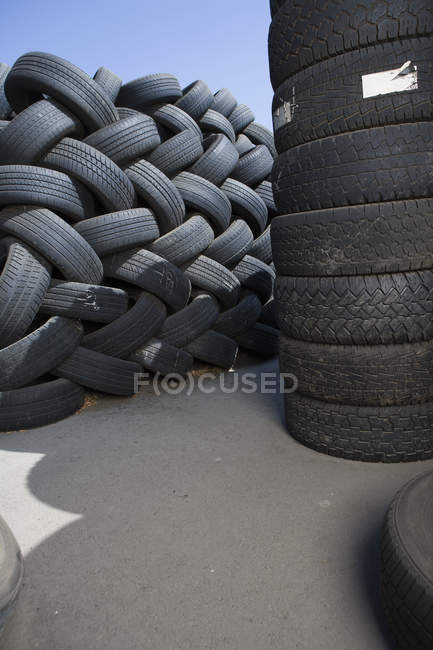 Pali di pneumatici usati per autoveicoli accatastati all'aperto — Foto stock