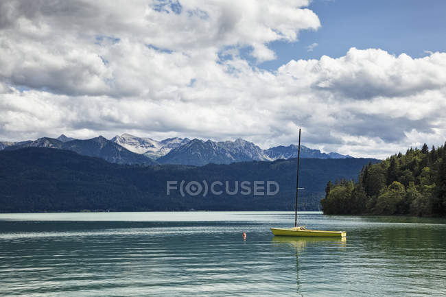 Sailboat moored in lake with woods and mountains in landscape, Germany — Stock Photo