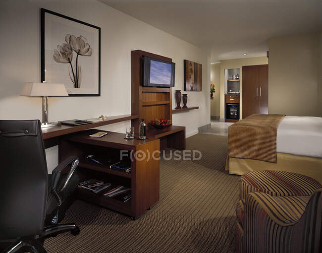 Hotel room with office space and tv — Stock Photo