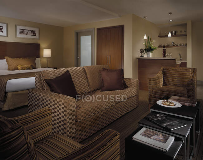 Habitación de hotel con sofá, sillones y bar - foto de stock