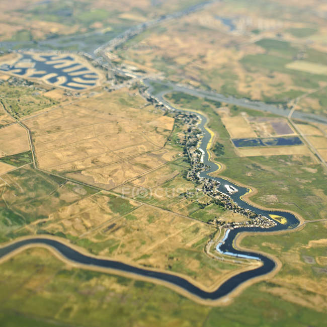 Vue aérienne de la rivière à travers les terres agricoles en Californie, États-Unis — Photo de stock