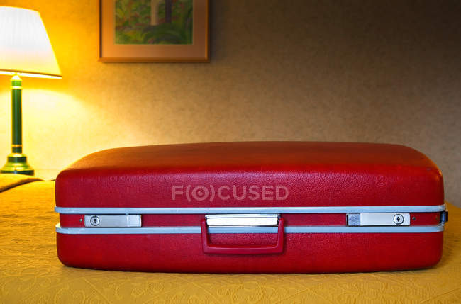Крупним планом червона валіза в кімнаті мотелю — стокове фото