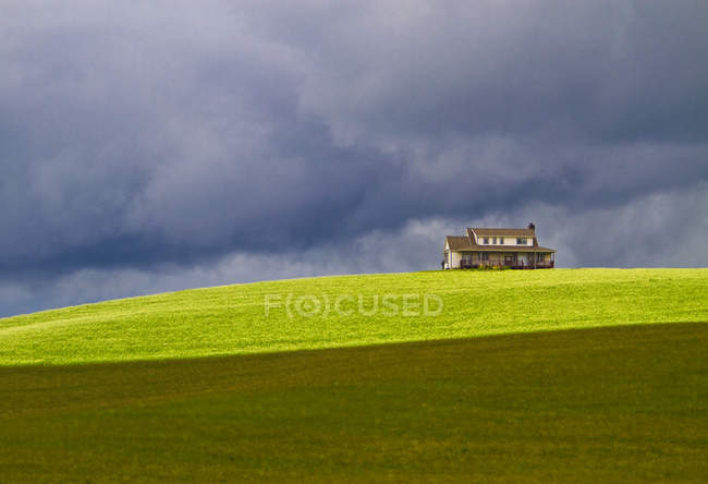 Pastagem e casa em ambiente rural sob tempestuoso céu dramático, Oregon, EUA — Fotografia de Stock