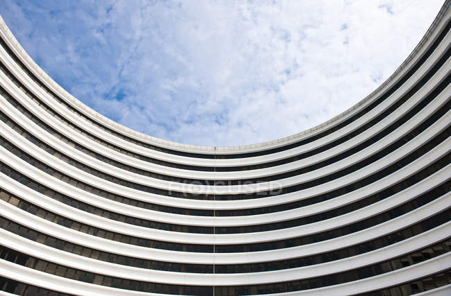Moderno edificio curvo contro cielo nuvoloso blu, Hong Kong, Cina, Asia — Foto stock