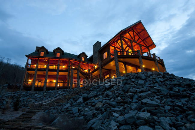Grande hotel de madeira à noite com iluminação, vista de baixo ângulo — Fotografia de Stock