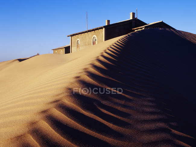 Casa sepolta in dune di sabbia con increspature modello sulla superficie — Foto stock