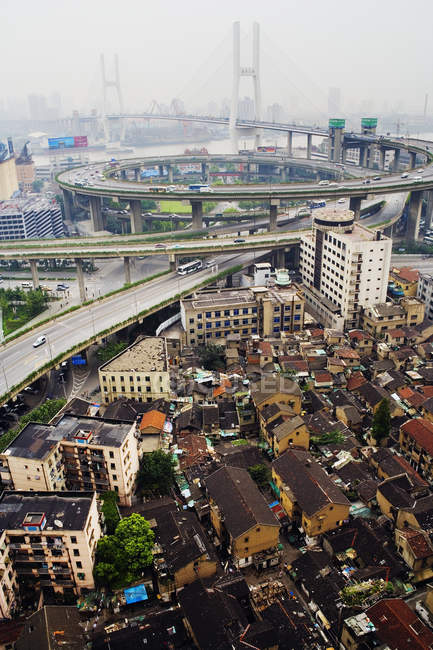 Slum housing with Nanpu Bridge in distance, Shanghai, China — Stock Photo