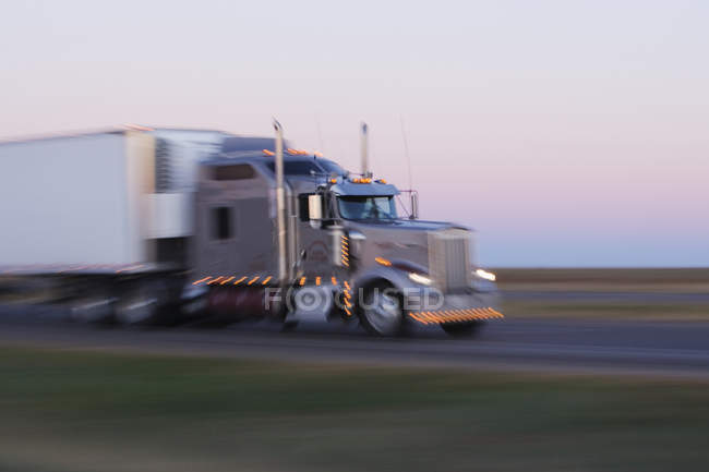 Camión montando en la carretera 287 de Texas al amanecer, EE.UU. - foto de stock