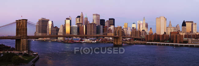 El horizonte del Bajo Manhattan y el Puente de Brooklyn al amanecer, Nueva York, EE.UU. - foto de stock