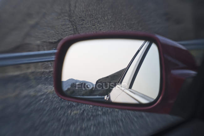 Parte de trás do carro no espelho com reflexão paisagem rural — Fotografia de Stock