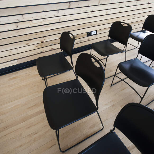 Високий кут зору порожніх чорних стільців в аудиторії — стокове фото