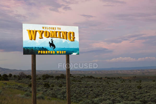 Ковбой на баккінг Bronco на Ласкаво просимо в Вайомінг знак, штат Вайомінг, Сполучені Штати — стокове фото