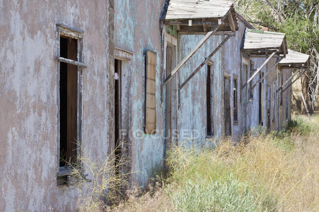 Quartos Abandonados Motel e grama alta durante o dia — Fotografia de Stock