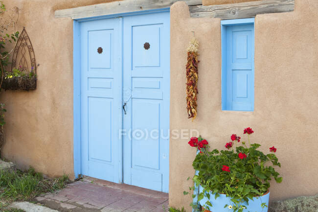 Дверь с висящим на стене перцем чили — стоковое фото