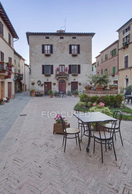 Plaza medieval con mesa y sillas en Pienza, Toscana, Italia - foto de stock