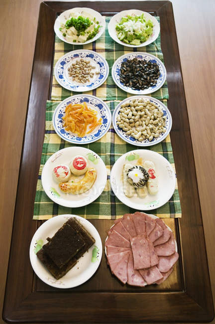 Два ряда азиатских блюд на обеденном столе — стоковое фото