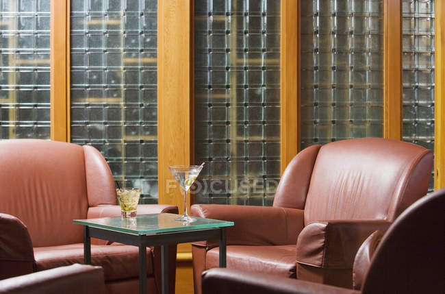 Área de estar cadeiras e mesa com bebidas no interior do apartamento moderno — Fotografia de Stock