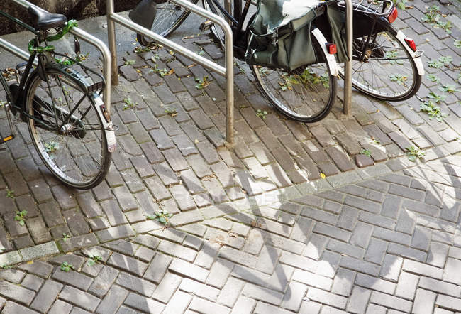 Bicicletas estacionadas en bastidores en la calle de la ciudad - foto de stock