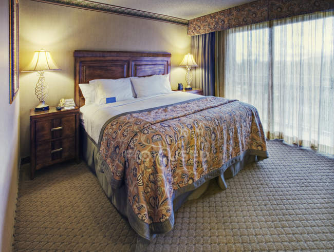 Queen bedroom set in hotel room — Stock Photo