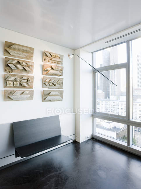 Arte e banco na parede em apartamento highrise luxo — Fotografia de Stock