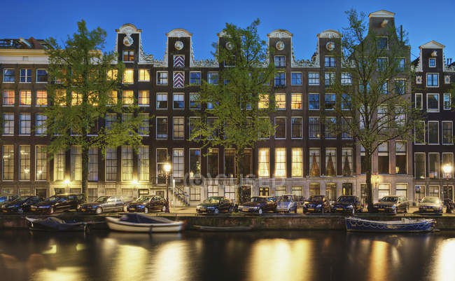 Cars and canal-front houses at night in Amsterdam, Netherlands — Stock Photo