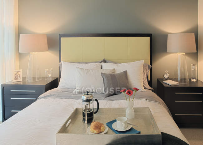 Завтрак на подносе в спальне в роскошном номере отеля — стоковое фото