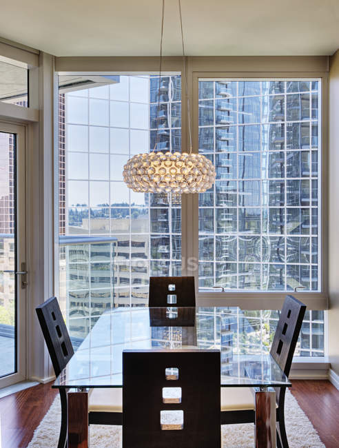 Chandelier over dining room in luxury highrise apartment — Stock Photo