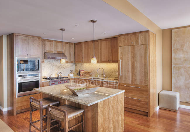 Armários de madeira na cozinha de luxo no apartamento moderno — Fotografia de Stock