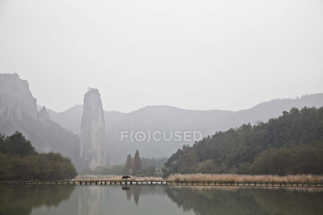 Paysage au bord du lac avec orignal sur pont et montagnes, Pékin, Chine — Photo de stock