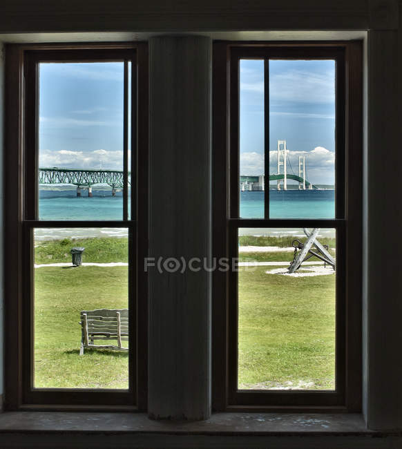 Vista frente al mar desde la ventana con césped y paisaje urbano, Michigan, EE.UU. - foto de stock