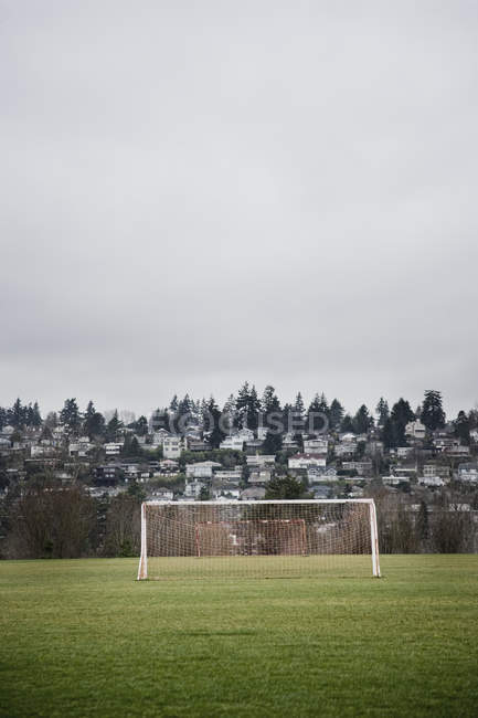 Filets de but sur le terrain de football dans le paysage de la ville — Photo de stock