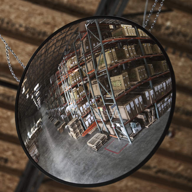 Cardboard boxes on shelves in warehouse reflection in mirror — Stock Photo