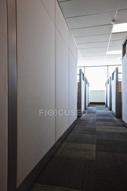 Salón alfombrado con cubículos de oficina en edificio moderno - foto de stock