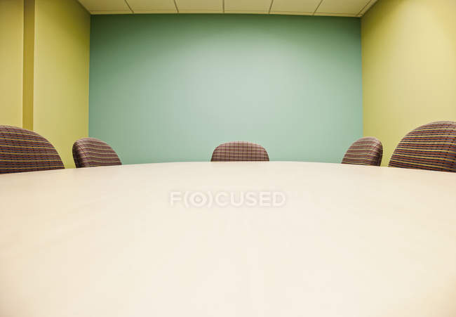 Стол для переговоров и стулья с зеленой стеной — стоковое фото