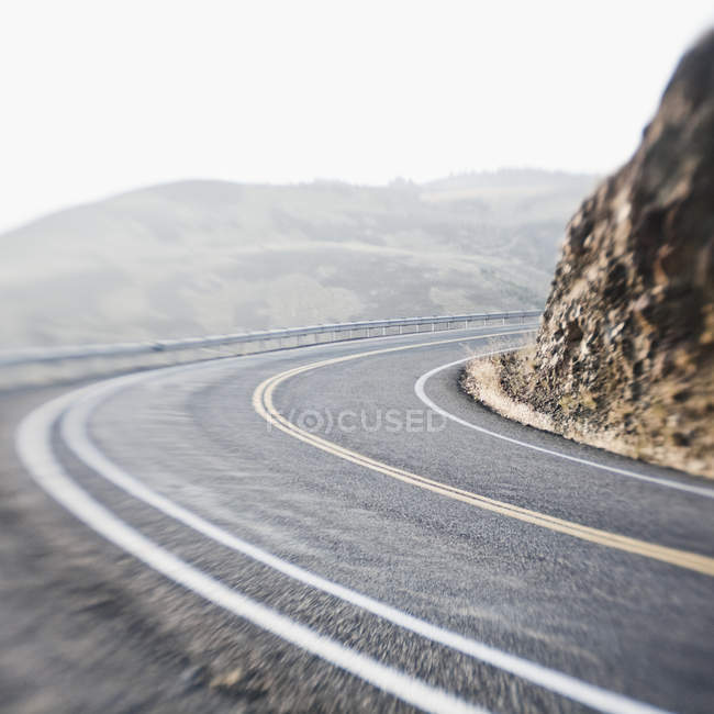 Вигинаючи дві смуги дороги в горах, розмиті, Вашингтон, США — стокове фото