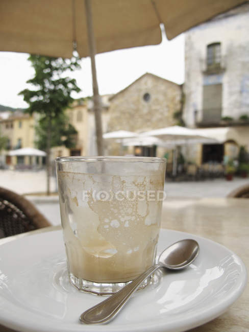 Close-up of empty glass on saucer at street cafe table in Besalu, Spain — Stock Photo