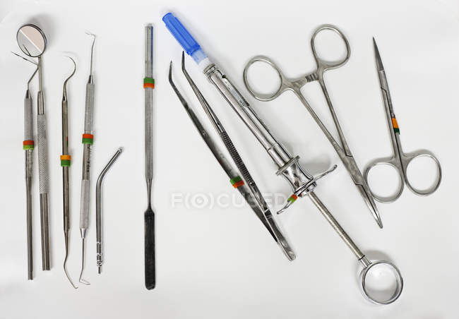 Стоматологические инструменты на белой поверхности, вид сверху — стоковое фото