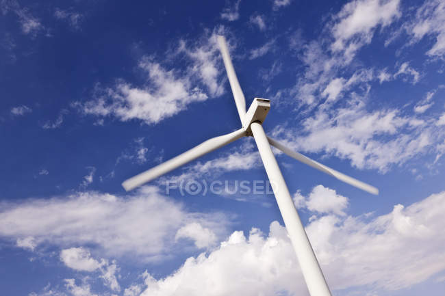 Turbina de viento bajo las nubes en el cielo azul - foto de stock