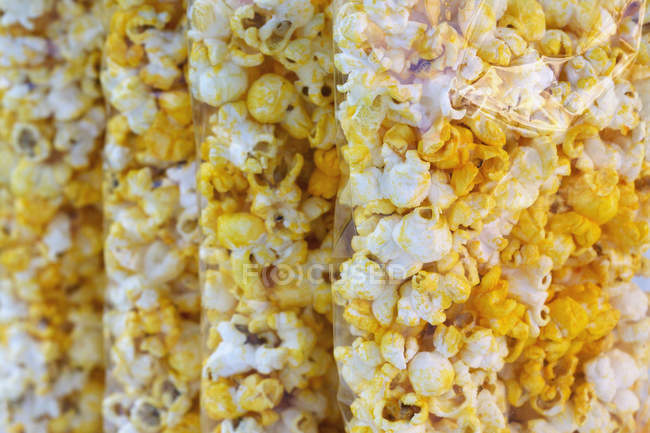 Tüten mit aromatisierten Popcorn-Snacks, voller Rahmen — Stockfoto