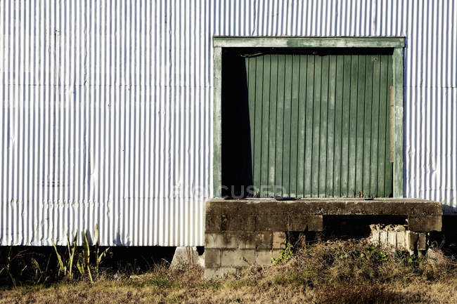 Porta del magazzino ondulato e parete della facciata — Foto stock